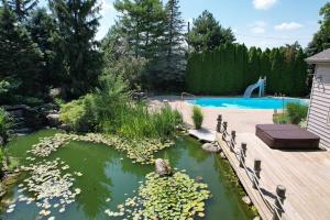 a pond with flowers and a swimming pool at Charming School House with Large Pool in Huron