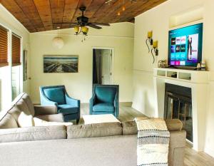a living room with a couch and chairs and a tv at Newly Renovated! Old Homestead Beach Home in Huron