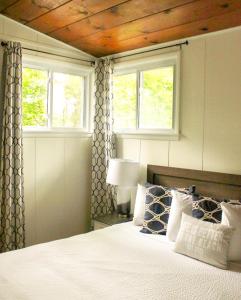 a bedroom with a bed with two windows and a bed sidx sidx sidx at Newly Renovated! Old Homestead Beach Home in Huron