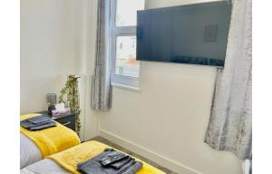 a bedroom with a bed and a tv on the wall at Cardiff City Centre Apartment- Penarth Road in Cardiff