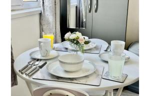 een witte tafel met borden en keukengerei erop bij Cardiff City Centre Apartment- Penarth Road in Cardiff