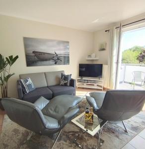 een woonkamer met een bank en een tv bij Appartment Relaxtage in Zingst