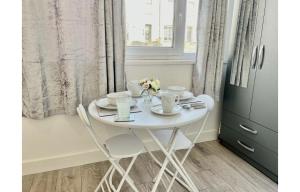een witte tafel en stoelen in een kamer met een raam bij Cardiff City Centre Apartment- Penarth Road in Cardiff