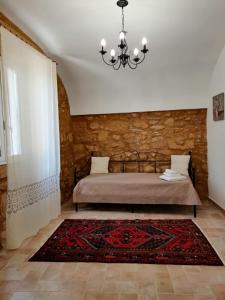 um quarto com uma cama e um lustre em Le Stanze dell'Emiro em Sambuca di Sicilia