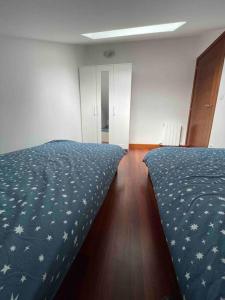 a bedroom with a bed with a blue comforter at Amplio piso Duplex en Elorrio. in Elorrio