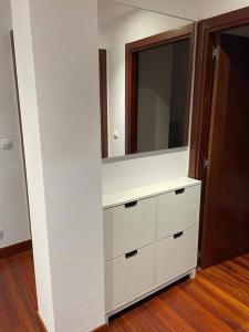 a white dresser with a mirror in a room at Amplio piso Duplex en Elorrio. in Elorrio