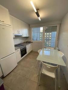 a kitchen with a white table and chairs in it at Amplio piso Duplex en Elorrio. in Elorrio