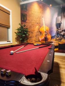 a pool table in a living room with a guitar at The Jazz Club in Sandusky