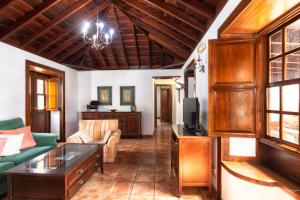 een woonkamer met een bank en een tv bij Lightbooking La Morera Villa de Mazo con piscina in Mazo