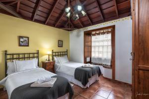 una camera da letto con due letti e una finestra di Lightbooking La Morera Villa de Mazo a Mazo Altre 10 foto