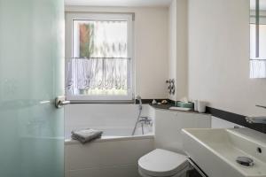 a bathroom with a tub and a toilet and a sink at Ferienwohnung Feine Natur in Bahlingen +25 photos