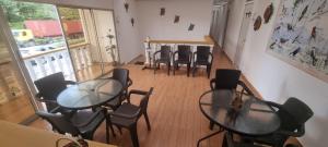 a room with tables and chairs and a balcony at Hostal Mochileros Inn in Circasia