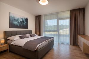 1 dormitorio con cama grande y ventana grande en TALBERG SK - Garage parking - Quiet place - Brand new apartments - Tále, en Tale
