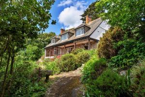 uma casa numa colina com uma estrada de terra em frente em Finest Retreats - Tregatreath em Coverack