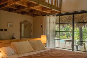 um quarto com uma cama e uma grande janela em La Colmena RD em Santa Bárbara de Samaná