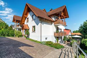 un gran edificio blanco con techos de madera y balcones en Ferienwohnung Liebich en Bühl