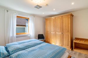 1 dormitorio con 1 cama azul y armario de madera en Ferienwohnung Liebich en Bühl