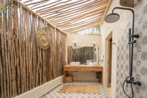 baño con pared de madera y 2 lavabos en La Colmena RD, en Santa Bárbara de Samaná