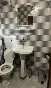 a bathroom with a toilet and a sink at Хотел механа Караджейката in Gradets