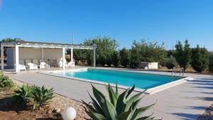 a swimming pool with a pergola next to a house at Casa Collis in San Leone