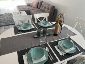 einen Esstisch mit Tellern und Weingläsern in der Unterkunft HANDLER Apartman Sopron in Sopron