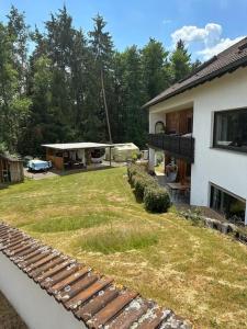 einen Hinterhof eines Hauses mit einem Garten voller Gras in der Unterkunft Urlaubstraum am Brombachsee- 5 stilvolle Zimmer- in Pleinfeld