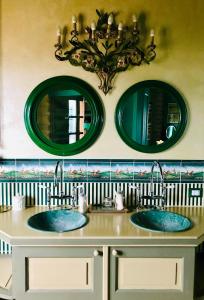 twee wastafels in een badkamer met twee spiegels bij Tenuta il Galletto in Casale Monferrato