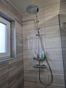 y baño con ducha con cabezal de ducha. en Orange house Šempeter, en Šempeter v Savinjski Dolini