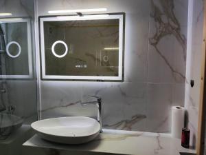 baño con lavabo blanco y ventana en Nasis Home & Apartments, en Mitikas