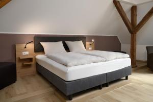 um quarto com uma cama grande e lençóis brancos em Hotel Preyt -Self Check In- em Holtlander Nücke
