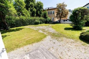 un patio de césped con una casa al fondo en City Center Rooms Kitzbühel, en Kitzbühel