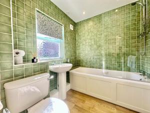 ein Badezimmer mit Waschbecken, Badewanne und Toilette in der Unterkunft Cherry Blossom Cottage in York