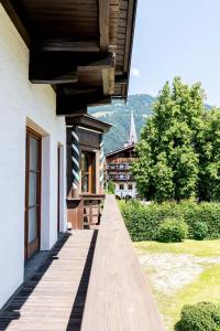 a building with a wooden walkway next to a house at City Center Rooms Kitzbühel in Kitzbühel