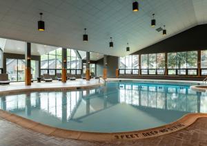 a large swimming pool in a large building with windows at Lodge at Schroon Lake in Schroon Lake