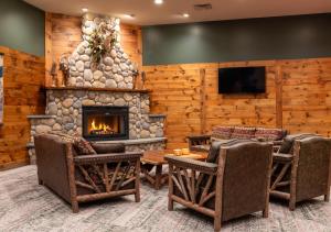 a living room with a fireplace and a tv at Lodge at Schroon Lake in Schroon Lake