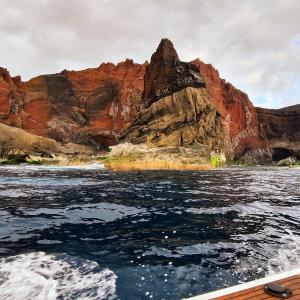 een boot in het water voor een berg bij Retiro dos Reis in Horta