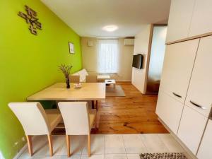a dining room with green walls and a table and chairs at Apartma Nataša in Jagodje