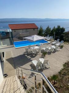 a group of chairs and a swimming pool on a house at APARTMAN U PRIZEMLJU S 2 SOBE in Stanići