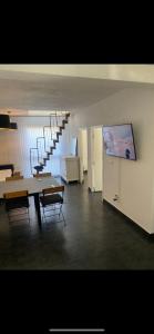 a room with a table and chairs and a staircase at APARTMAN U PRIZEMLJU S 2 SOBE in Stanići