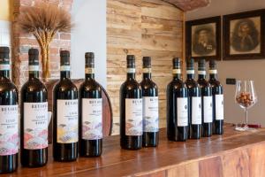 un montón de botellas de vino sentadas en un mostrador en Agriturismo Cantine Bevione - Family Apartments, en Farigliano