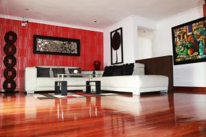 una sala de estar con 2 sofás y una pared roja. en Hotel Santiago de Compostella Suites en Cuenca