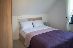 Łóżko lub łóżka w pokoju w obiekcie Apartamenty - Dom Smołdziński Las