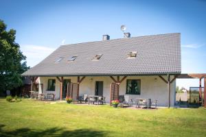 a house with tables and chairs on a yard at Apartamenty - Dom Smołdziński Las in Smołdziński Las