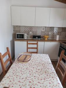 a kitchen with a table with a floral table cloth on it at A Casa do Barqueiro- Alentejo in Pedrógão