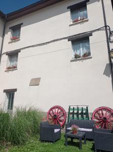 a white building with red wagon wheels and chairs at Agroturismo Biltegi Etxea 