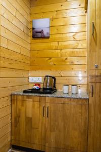 uma cozinha com paredes de madeira e um forno com placa de fogão em The Door to Nirvana Cottages em Coonoor
