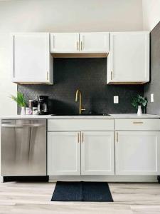 a kitchen with white cabinets and a sink at Leaning House of Haynie in Evansville