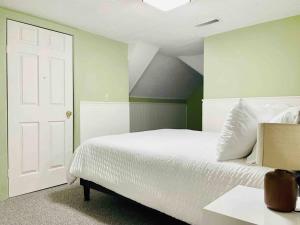 a bedroom with a white bed and a white door at Leaning House of Haynie in Evansville