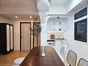 uma cozinha e sala de jantar com uma mesa de madeira e cadeiras em PB home 1 min to BTS Saladaeng & MRT Silom em Bang Rak
