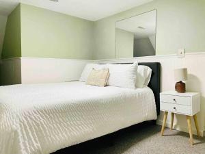 a bedroom with a white bed and a mirror at Leaning House of Haynie in Evansville